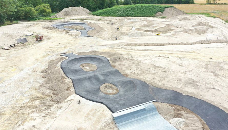 Multisportanlage Dingolfing während der Bauphase mit modellierten Pumptrackflächen und ersten asphaltierten Fahrbereichen