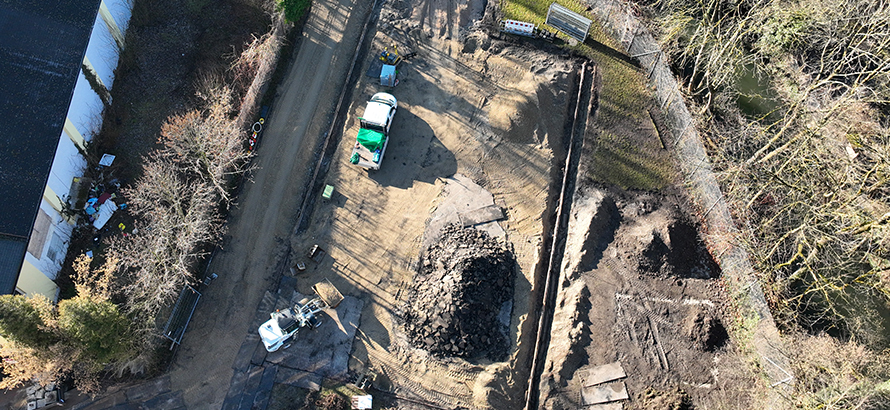 Allwetterplatz in Erding während der Bauphase mit freigelegtem Untergrund, Baumaschinen und ausgebautem Material